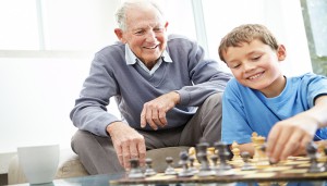 Grandfather and his grandson playing chess together