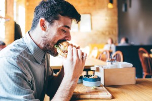 Man is eating in a restaurant and enjoying delicious food